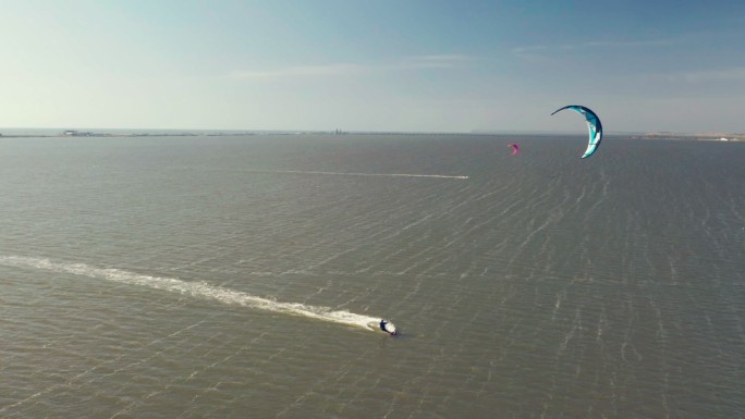 风筝冲浪者滑翔和跳跃穿越海洋的鸟瞰图