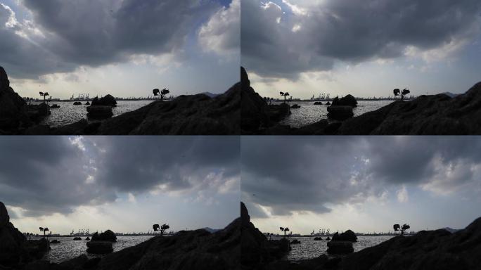 阳光刺破海边浓云间隔摄影