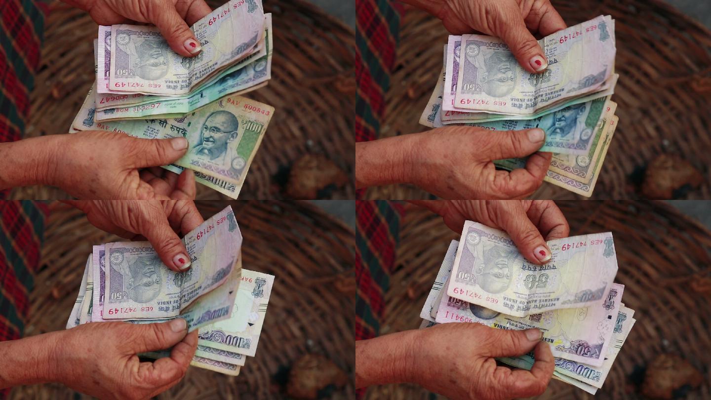 贫困概念。女人在数印度卢比钞票，特写镜头