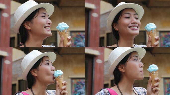 美丽的女游客在暑假戴着帽子吃着冰激凌