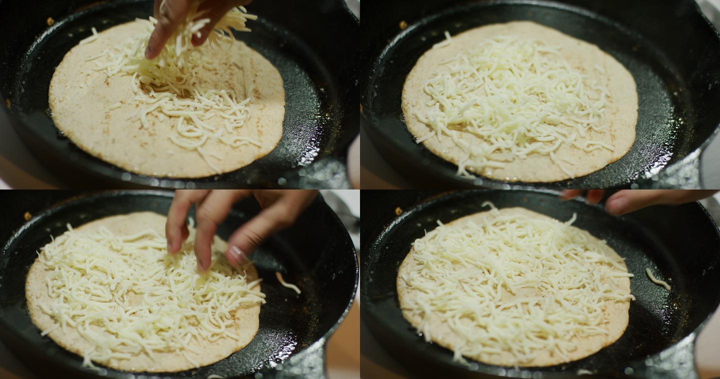 将磨碎的马苏里拉奶酪洒在玉米饼上