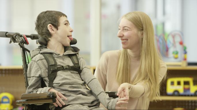 残疾小男孩与护理者交谈