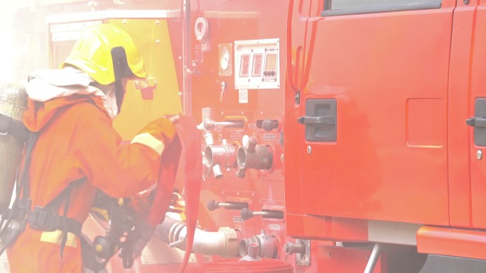 消防员携带消防水带连接至消防车阀门