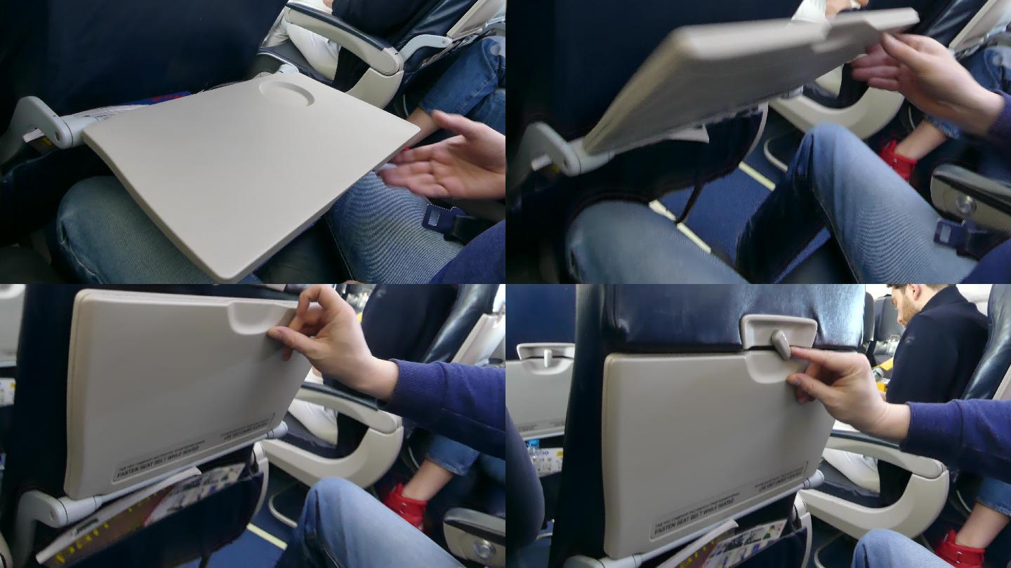 乘客在飞机上摆好桌子，飞机上飞行时折叠桌