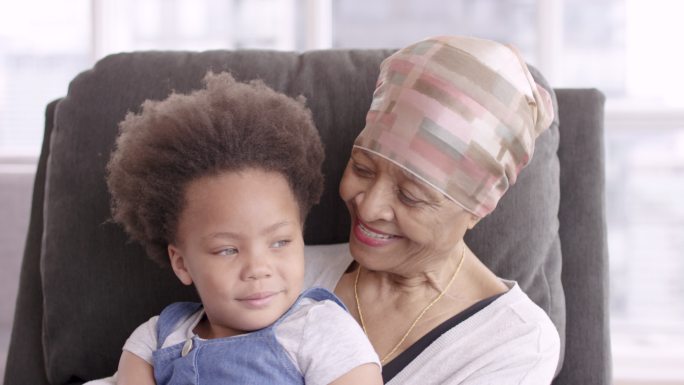 一位身患癌症的老年妇女深情地抱着孙女