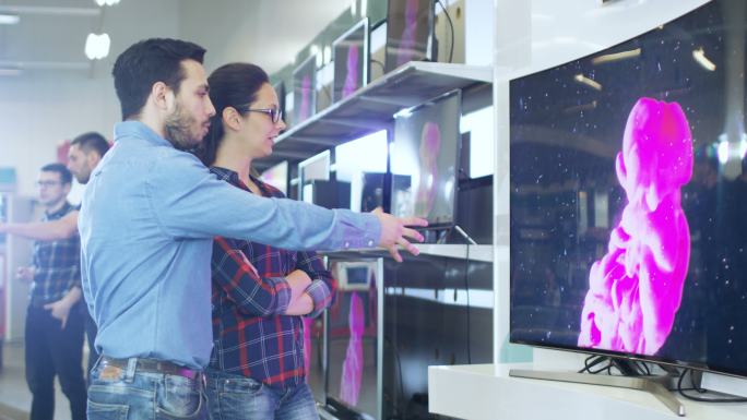 夫妇在商店购买一台新的4K超高清电视机