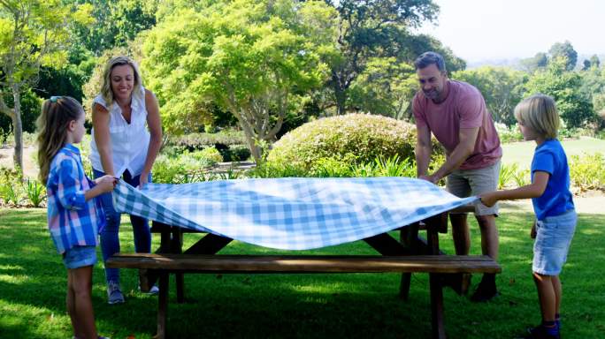 一家人在野餐桌上铺桌布