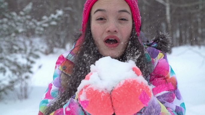 女孩朝镜头吹雪青少年吹风温暖的衣服