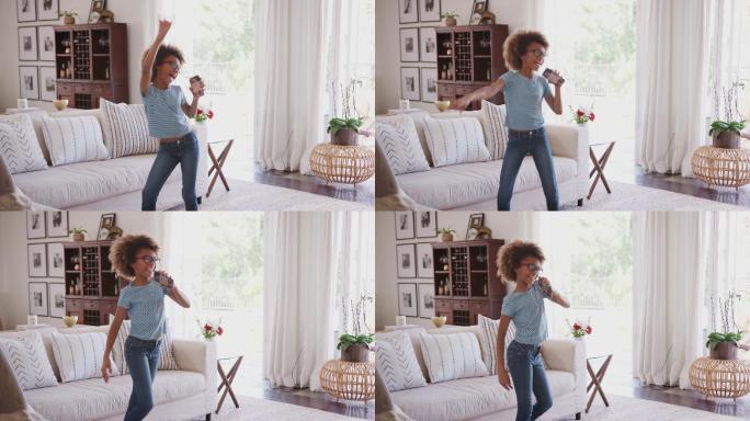 女孩在家里用手机作为麦克风跳舞唱歌