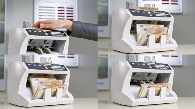 银行职员将50欧元钞票插入点钞机