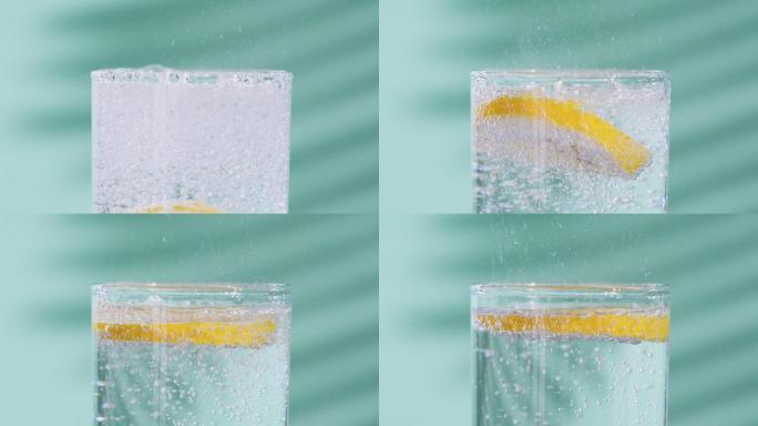 将一片柠檬投入一杯苏打水中慢镜头