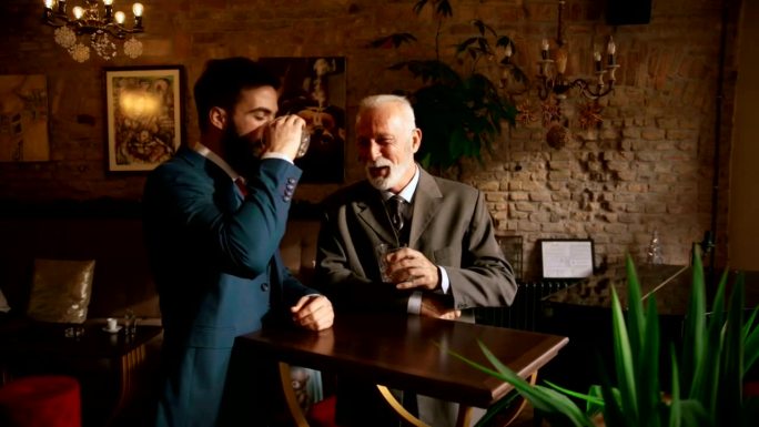 两个男人在酒吧边喝酒边聊天