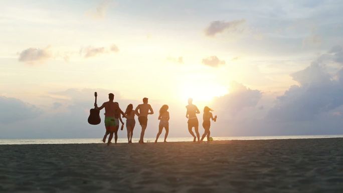 一群朋友在日落时在海滩上跑步