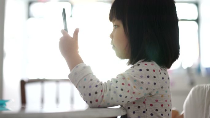 小孩拿着平板电脑的特写镜头。