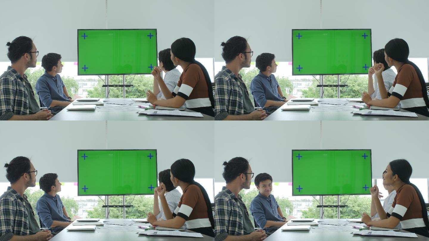 创意商业团队在会议室看着绿色屏幕鼓掌