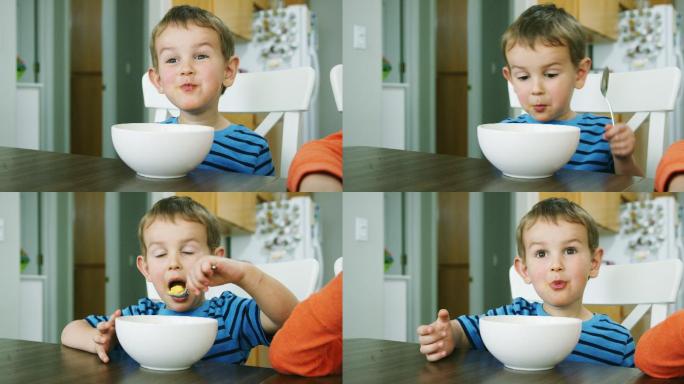 男孩在室内的餐桌上用勺子吃饭