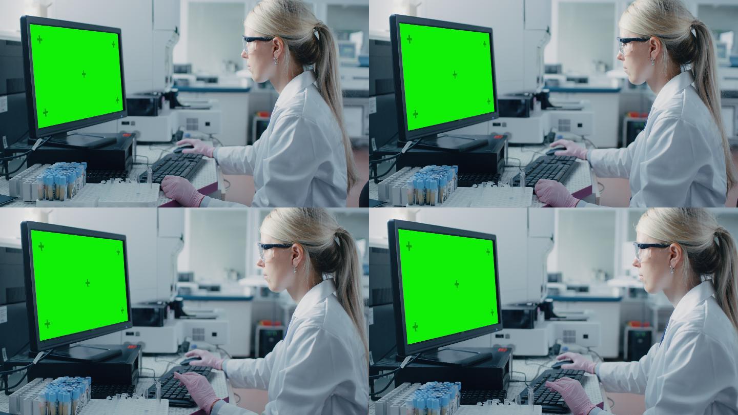 女生坐在实验室使用绿色屏幕的电脑。