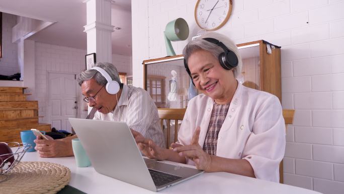 快乐老人使用笔记本电脑听音乐