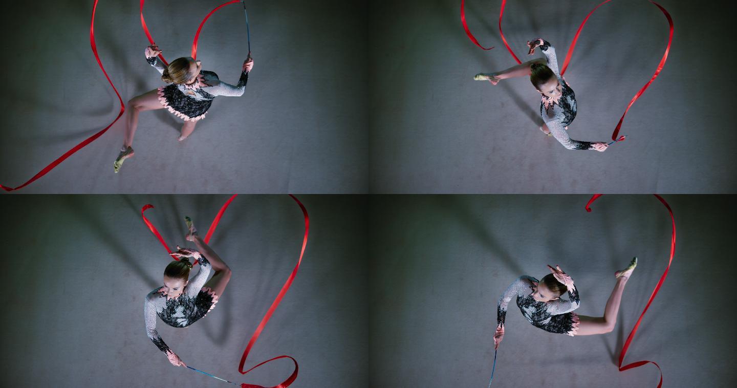 一名艺术体操运动员在表演旋转时拿着红丝带