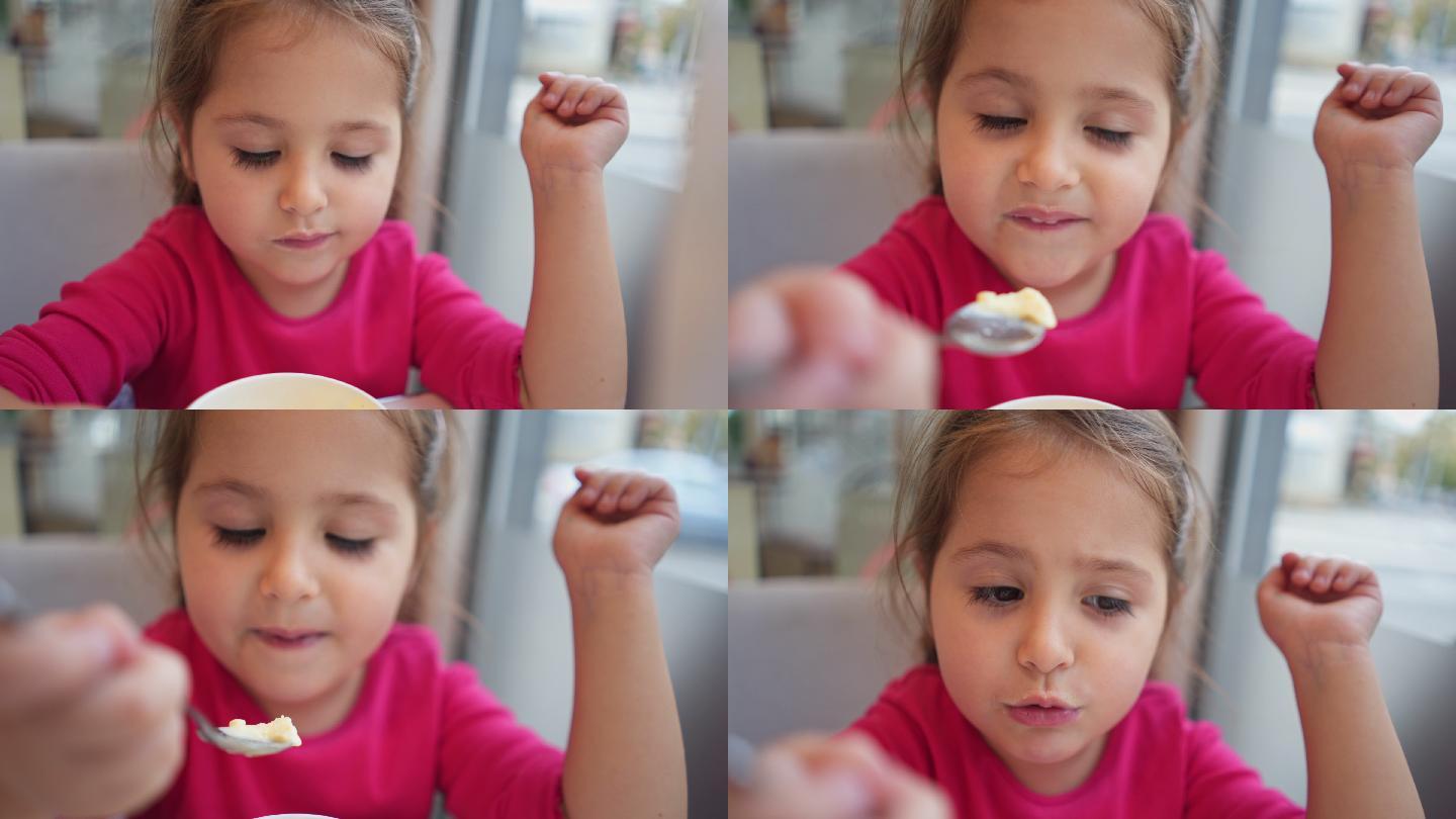 小女孩一边看手机一边吃冰淇淋