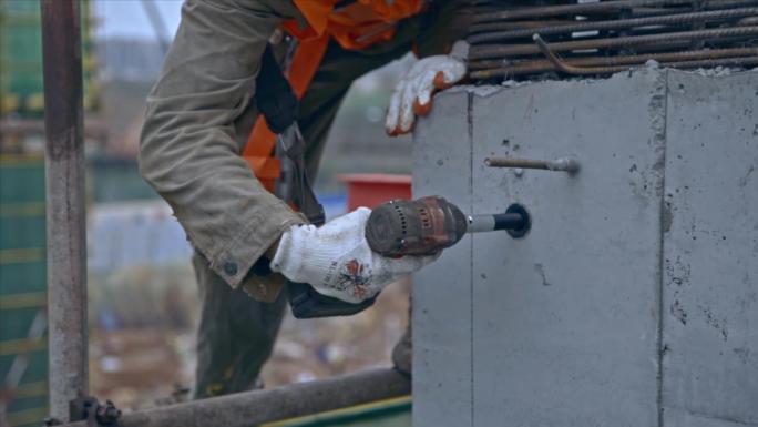 建筑工人安装悬挑钢梁的固定螺栓