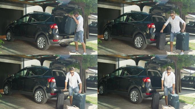 男子从黑色SUV中卸下沉重的行李箱。