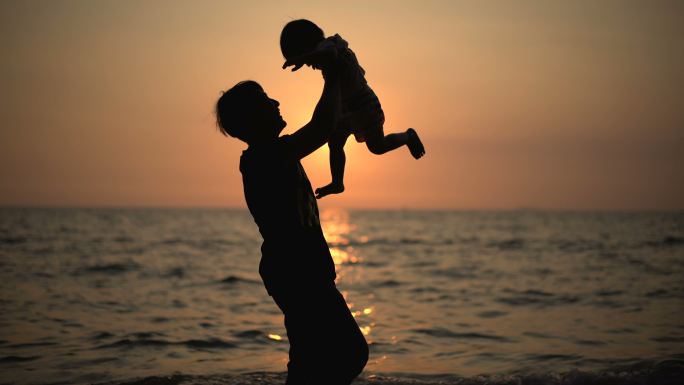父亲在海滩上抱着男婴。