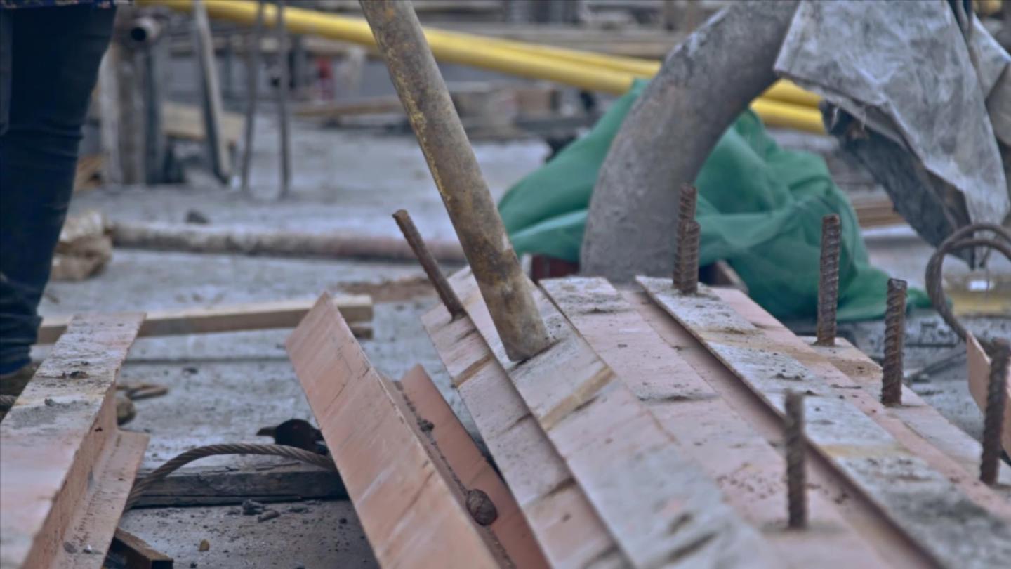 建筑工人在拆除以前焊接的脚手架固定杆