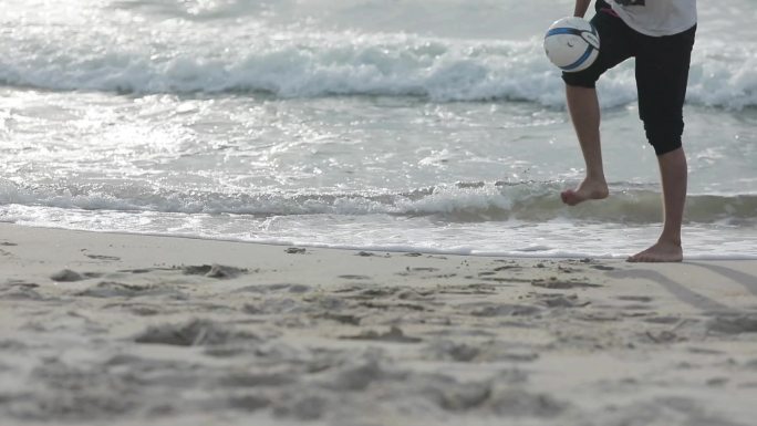 男子在海边踢足球浪花风浪颠球旅游度假