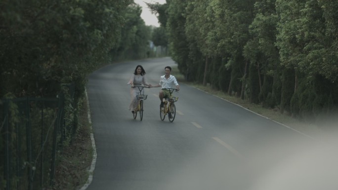情侣浪漫骑单车度假在丛林路上