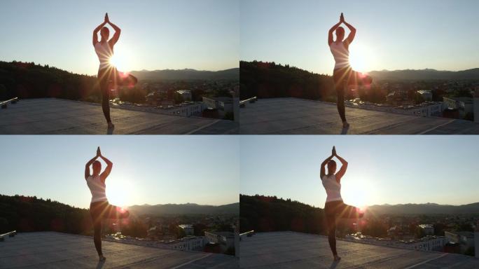女子在摩天大楼顶上做瑜伽