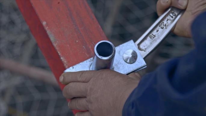 建筑工人安装脚手架的定位扣件