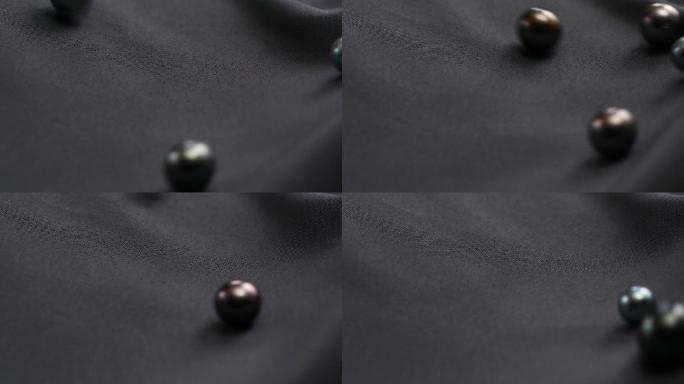 大溪地黑珍珠在丝绸上面滚落
