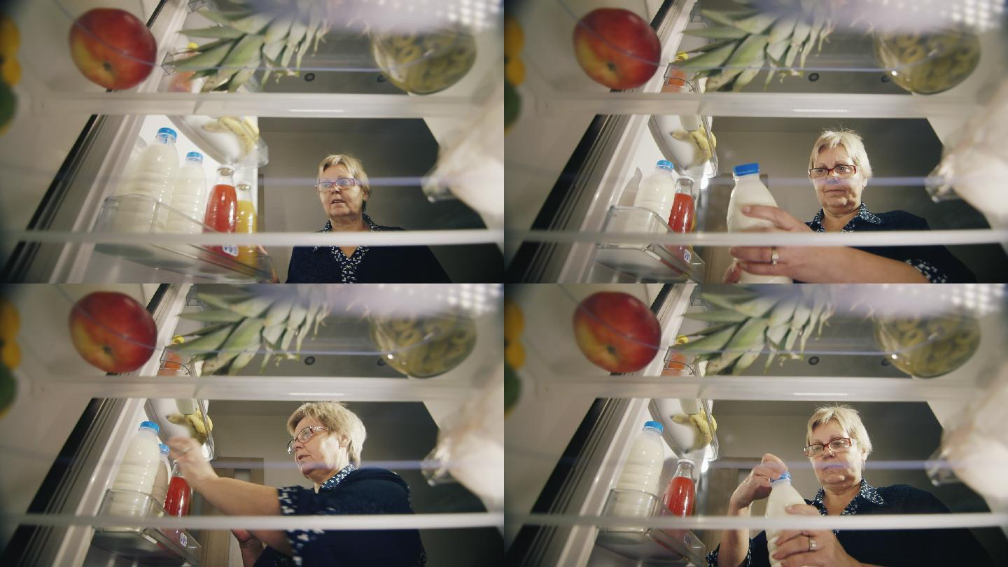 女士从冰箱里拿出牛奶，检查产品的保质期。