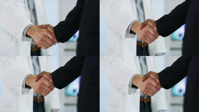 年轻男医生在医院与一位商人握手