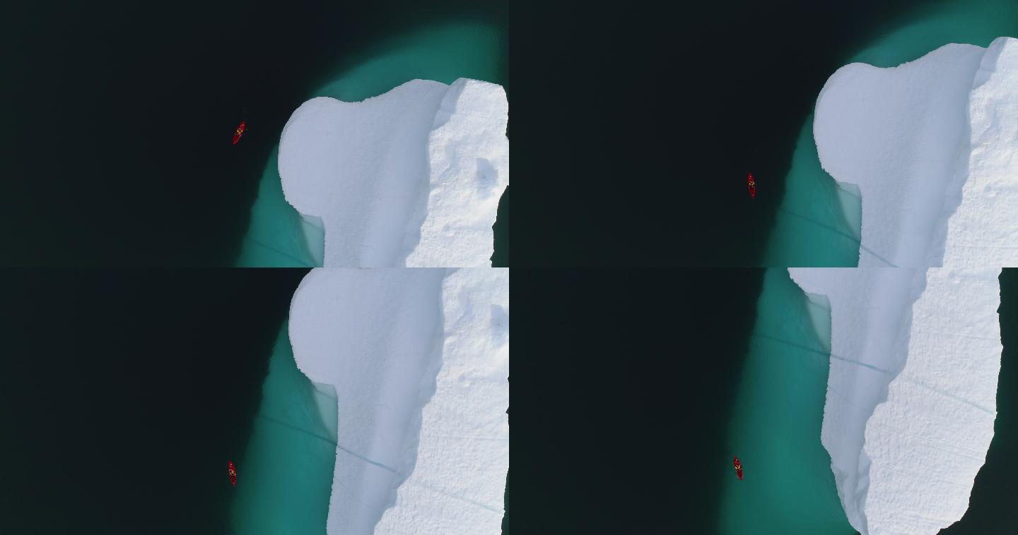 一艘皮划艇绕着冰山划过的空中镜头