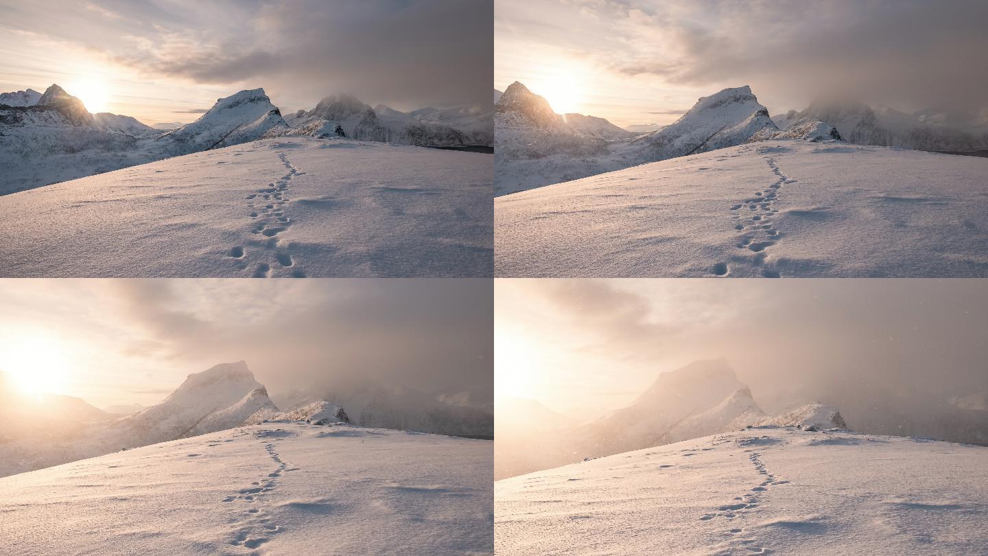 雪山山脉的时间推移与日出时雪地上的脚印