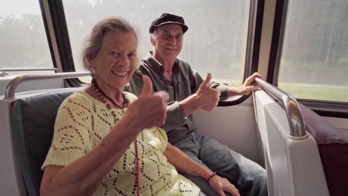 快乐的老年夫妇在地铁上竖起大拇指