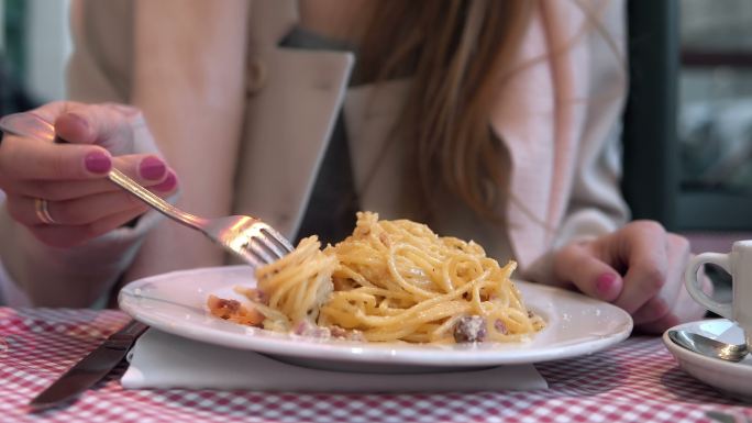 饥饿的女人在吃美味的意大利面