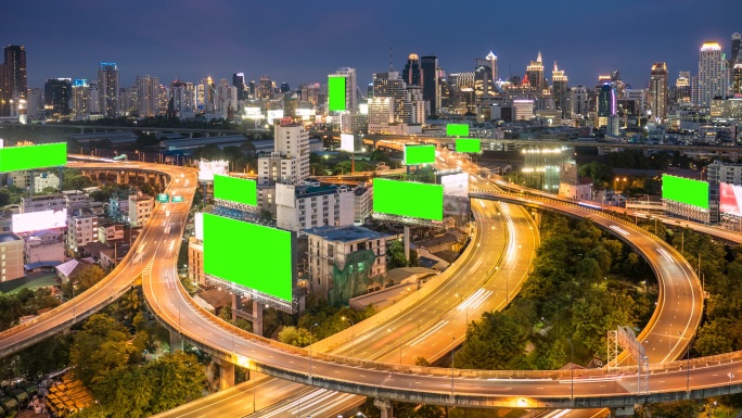 黄昏高速公路上的绿色屏幕广告牌