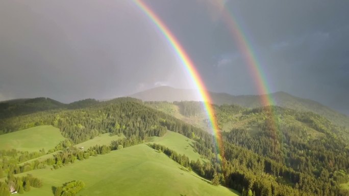 美丽的双彩虹掠过清新的绿色森林景观