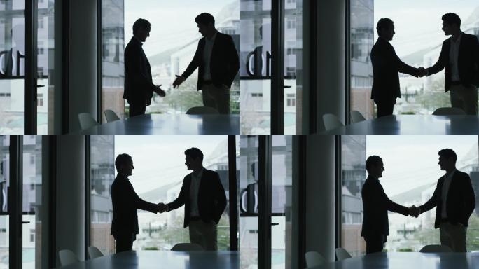 两位商务人士在会议室开会后握手