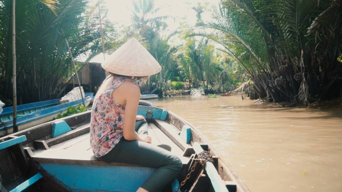 妇女乘船穿越湄公河三角洲