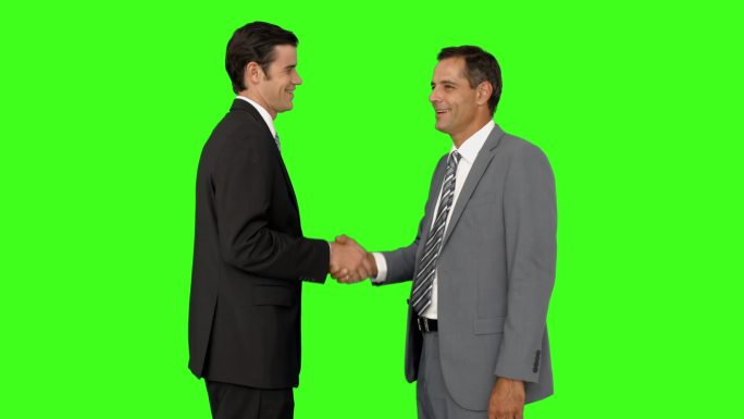 商人们在绿色屏幕背景上握手微笑
