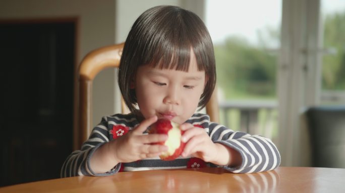 在吃苹果的小女孩幼儿小孩子开心天真笑容