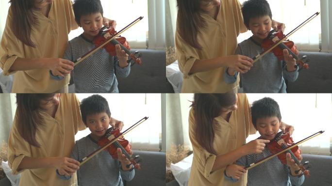快乐的小男孩在家学习拉小提琴