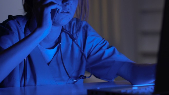 护士使用笔记本电脑和有声电话
