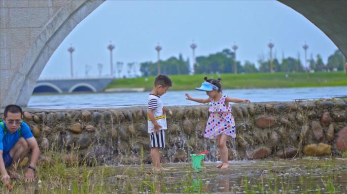 在水边玩耍的家长和孩子