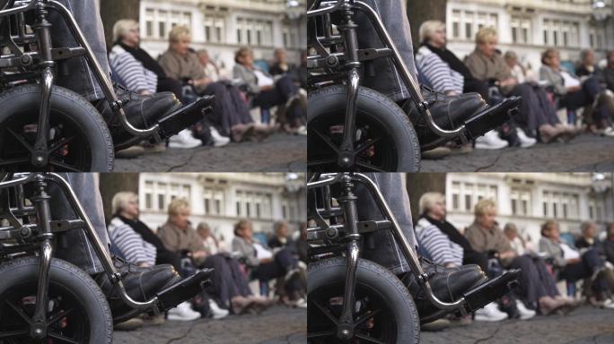 坐在轮椅上听街头音乐会的人