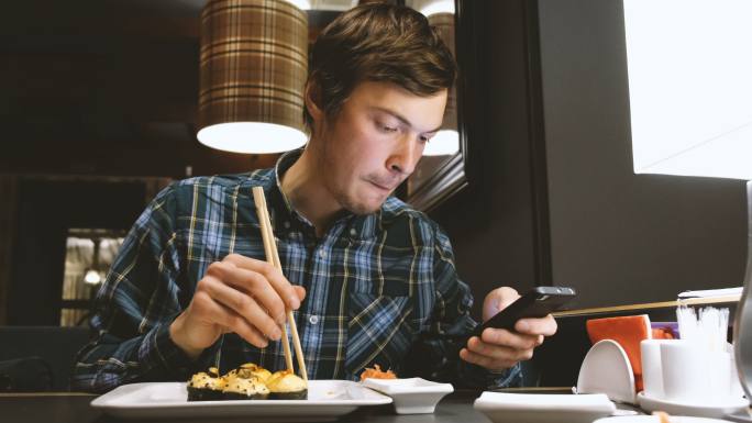 边吃寿司边玩手机